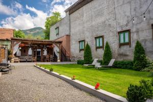 a building with a yard with chairs and a patio at Casa Ceauș in Baia-Sprie