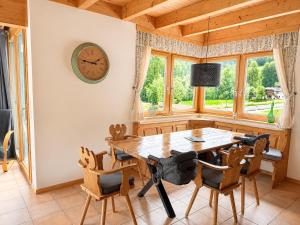 a dining room with a table and chairs and a clock at Gipfelruhe-ganzes Ferienhaus mit Sauna, Garten & Spielzimmer- Ramsau am Dachstein in Ramsau am Dachstein +43 photos