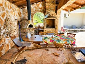 a living room with a table and a stone wall at Private Sea View with Infinity Pool in VILLA NERIN Zagora in Zagora
