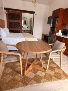 a room with a table and two chairs and a bed at Santa Delfina Suites in Flores +5 photos