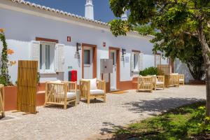 a row of chairs in front of a building at VILLA BRANDA - Tavira Nature Hotel in Tavira