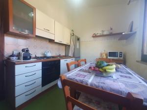 a kitchen with a table with a bowl of fruit on it at Casa Luisa in Sarroch
