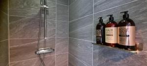 two bottles of wine sitting on a shelf in a shower at The Red Mini Cottage in Huddinge +20 photos