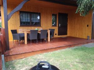 a deck with a table and chairs on a house at Bungalow Schwielochsee in Schwielochsee