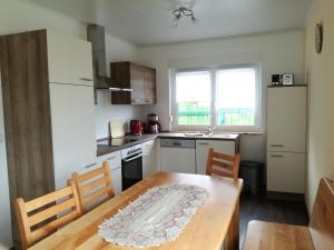 a kitchen with a wooden table and a table and chairs at Bungalow Schwielochsee in Schwielochsee