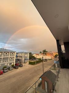 a rainbow in the sky over a city at Santa Delfina Suites in Flores