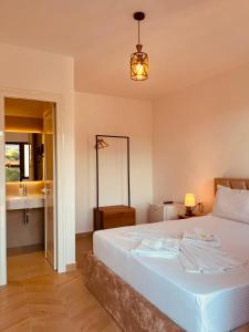 a bedroom with a large white bed and a sink at Villa Balliu in Berat