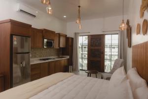 a kitchen with a large white bed in a room at Santa Delfina Suites in Flores