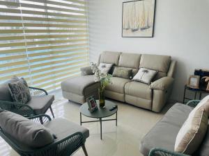 a living room with a couch and chairs and a table at Punta Centinela - Townhouse 200 in Punta Blanca