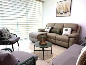 a living room with a couch and a table at Punta Centinela - Townhouse 200 in Punta Blanca +2 photos