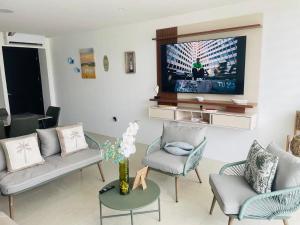 a living room with a couch and a tv at Punta Centinela - Townhouse 200 in Punta Blanca