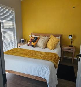 a bedroom with a large bed with yellow walls at R&R at Summerview Sonstraal Heights in Windsor Park