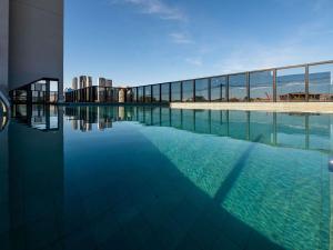 a swimming pool in front of a building at Novotel Uberlândia in Uberlândia