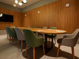 a conference room with a wooden table and chairs at Novotel Uberlândia in Uberlândia