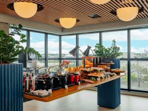 a buffet line with food on a table with windows at Novotel Uberlândia in Uberlândia +151 photos