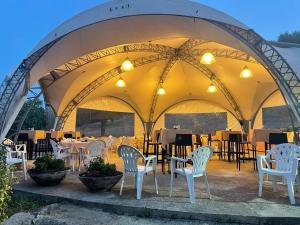 a group of white chairs and tables in a tent at Locanda a Bosco in Bosco
