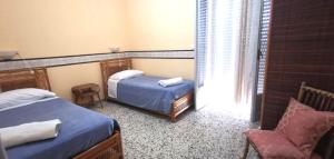 a bedroom with two beds and a chair and a window at Locanda a Bosco in Bosco