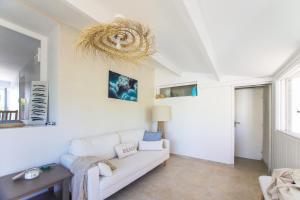 a living room with a white couch and a table at Villa Trafal - Proche plage in Saint-Michel-en-lʼHerm