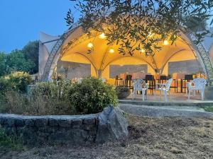 a gazebo with white chairs and a table at Locanda a Bosco in Bosco
