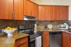 a kitchen with wooden cabinets and a bowl of fruit at Boho 2BR Retreat - Ocean View Terrace & Pool in Buena Vista