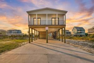 a house on a boardwalk in front of some houses at Bright Waves Fort Morgan in Gulf Shores