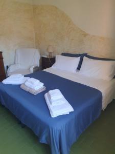 a bedroom with a blue bed with towels on it at Casa Luisa in Sarroch