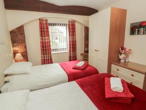 a bedroom with two beds and a window at The Coach House in Wigton