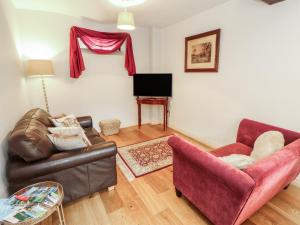 a living room with a couch and a chair at Millers Cottage in Wigton +13 photos