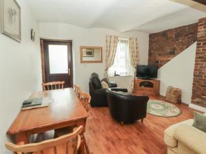a living room with a wooden table and a dining room at The Coach House in Wigton