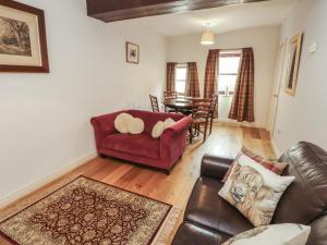 a living room with a couch and a table at Millers Cottage in Wigton