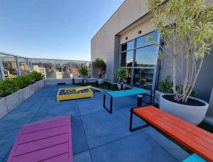 a patio with benches and tables on a building at Studio Luxo Completo Independência 915- São Mateus in Juiz de Fora