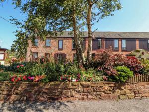 a brick house with flowers in front of it at Millers Cottage in Wigton