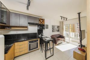 a kitchen with a table and a couch in a room at Studio Luxo Completo Independência 915- São Mateus in Juiz de Fora
