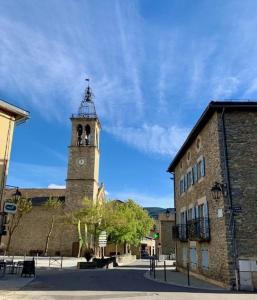 a building with a tower with a clock on it at Apartamento-Estudio in Osséja +2 photos