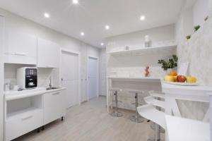 a kitchen with white cabinets and a bowl of fruit on the counter at Rooms Sorrento in Sorrento