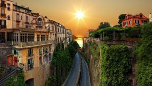 a view of a winding road between buildings at sunset at Rooms Sorrento in Sorrento +1 photo