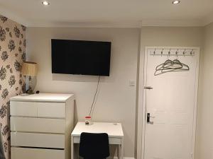 a bedroom with a desk and a television on the wall at Dublin Cosy Home in Dublin