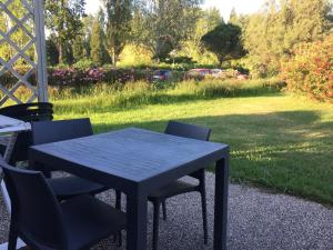 a black table and chairs in a yard at Appartement village 7 in Arles