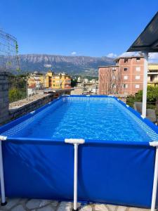 a large blue swimming pool on top of a building at Apartament Drasa in Gjirokastër
