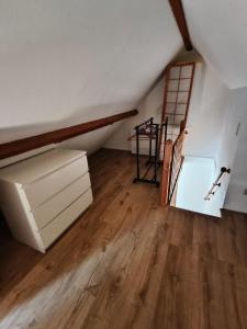 a attic room with a staircase and wooden floors at Gîte - La Gariotte du Causse in Frayssinet