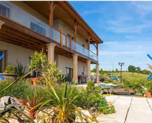 a large building with a balcony and a playground at La Découverte, Jacuzzi, Sauna, et Terrasse avec vue sur lac à la campagne entre Toulouse et Auch in Catonvielle