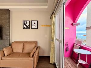a living room with a couch and a pink wall at I WoW in Xiaoliuqiu