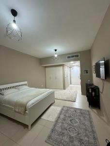 a bedroom with a large bed and a television at Cosy Studio - Desert Breeze in Ghantoot