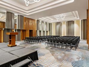 a conference room with chairs and a podium at Mercure Abu Dhabi Downtown in Abu Dhabi +111 photos