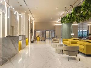 a lobby with yellow couches and chairs in a building at Mercure Antalya Belek in Belek