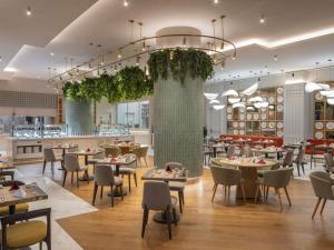a restaurant with tables and chairs and a bar at Mercure Antalya Belek in Belek