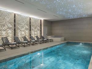 a swimming pool with chairs and a star ceiling at Mercure Antalya Belek in Belek +112 photos