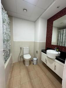 a bathroom with a toilet and a sink and a mirror at Cosy Studio - Desert Breeze in Ghantoot +3 photos