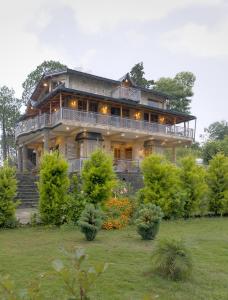 a large house with a large deck on a yard at Pine Grey Castle in Almora