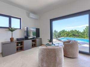 a living room with two chairs and a large window at Villa Florinda by Interhome in Raša
